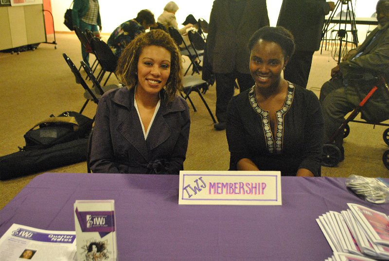 Two women at an IWJ mebership table ready to help people sign up.
